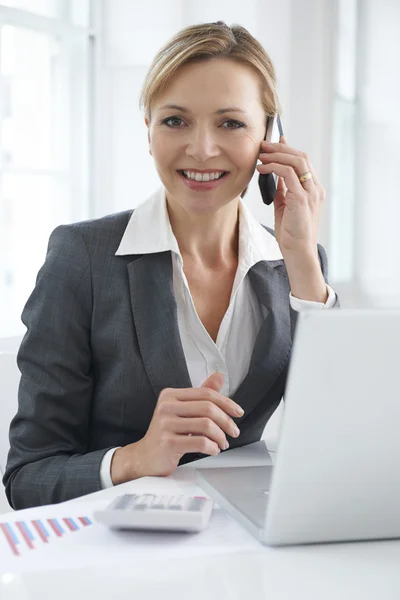 Бізнес-леді працює на столі на мобільному телефоні — стокове фото