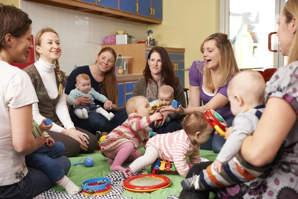 Grupo de madres con bebés en el grupo de juegos Imagen De Stock