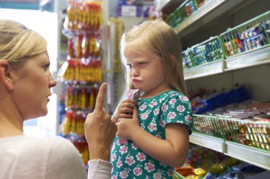 Child Having Arguement With Mother At Candy Counter clipart