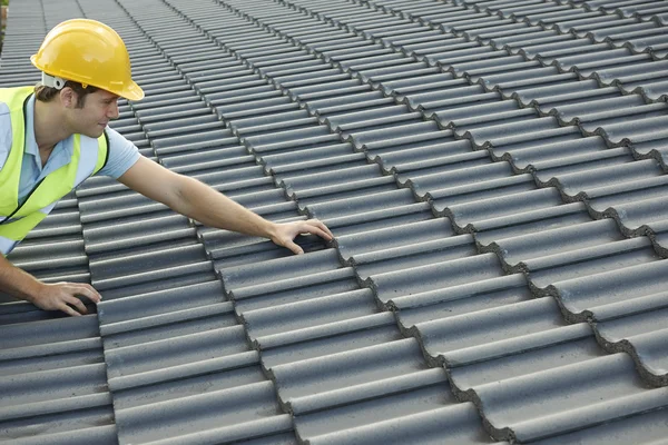 Bouwer werkt aan dak van nieuwbouw — Stockfoto