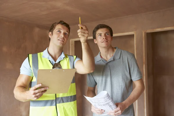 Construtor e inspetor olhando para nova propriedade — Fotografia de Stock