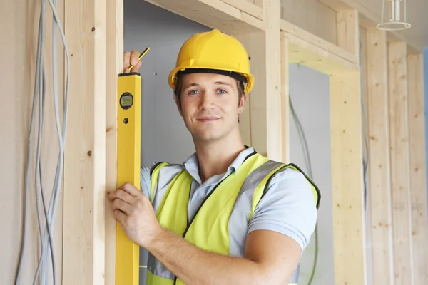 Construtor verificando o trabalho com nível de espírito — Fotografia de Stock