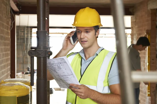 Bauarbeiter mit Handy vor Ort — Stockfoto