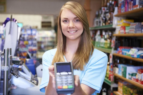 Mujer Asistente de ventas que sostiene la máquina de tarjeta de crédito — Foto de Stock