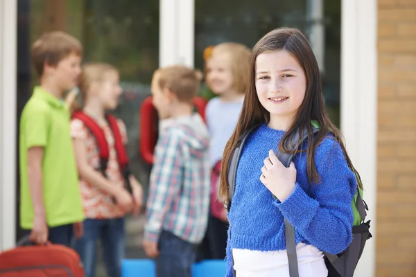 Девушка, стоящая возле школы с рюкзаком — стоковое фото