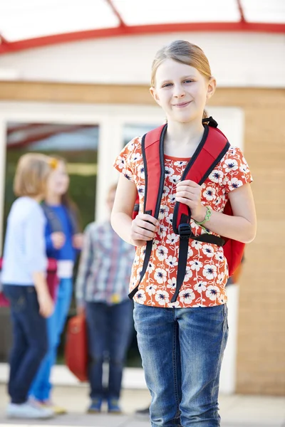 Mädchen steht mit Rucksack vor der Schule — Stockfoto