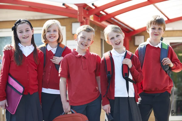 Porträt von Schulkindern außerhalb des Klassenzimmers, die Taschen tragen — Stockfoto