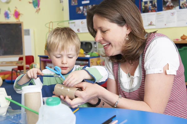 Enseignant aidant le petit garçon à construire le modèle dans la classe d'art — Photo