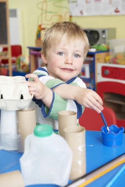 Pojke byggnad skräp modell i förskola klass — Stockfoto