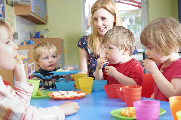 Insegnante con bambini in età prescolare mangiare spuntini sani a colazione — Foto Stock