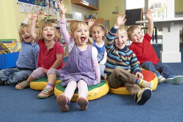 Group Of Pre School Children Answering Question In Classroom Stock Image