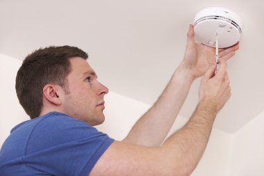 Man Installing Smoke Or Carbon Monoxide Detector clipart