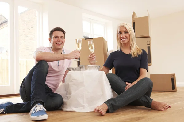 Casal comemorando mudança para nova casa com champanhe — Fotografia de Stock