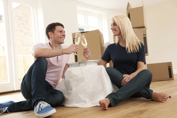 Casal comemorando a mudança para a nova casa com champanhe e Takea — Fotografia de Stock