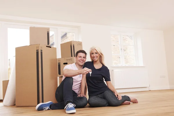 Casal movendo-se para a nova casa segurando chaves — Fotografia de Stock