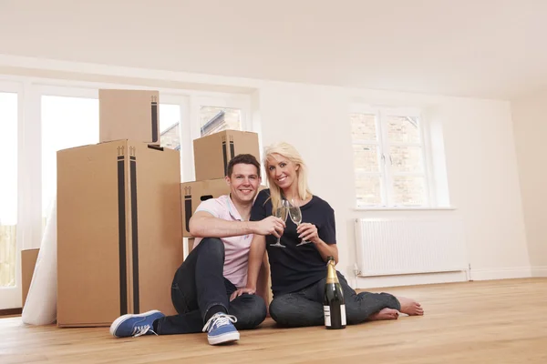 Casal comemorando mudança para nova casa com champanhe — Fotografia de Stock