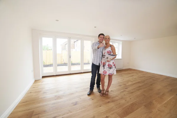 Couple With Property Details Looking Around New Home — Stock Photo, Image