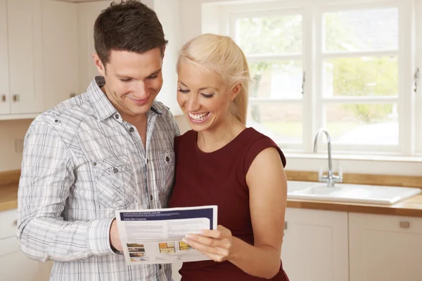 Young Couple Looking At Details For New Home — Stock Photo, Image