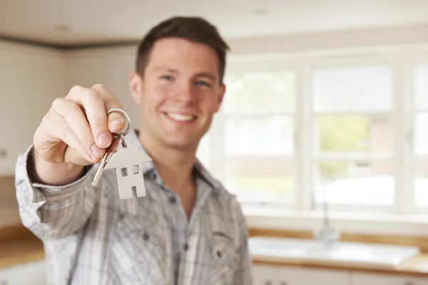 Anahtarlık şeklinde yeni ev Holding evime taşınmaya adam — Stok fotoğraf