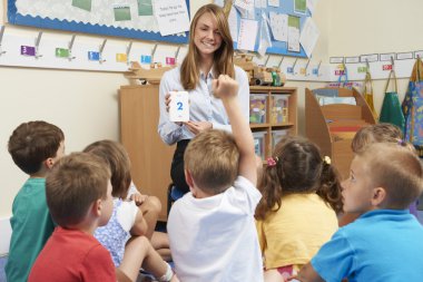 Öğretmen matematik öğretmek için numara birden parlamak oyun kağıdı kullanarak