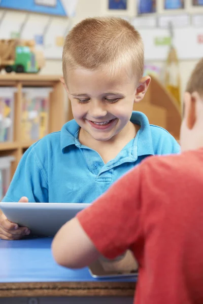 Aluno da escola primária usando tablet digital na sala de aula — Fotografia de Stock