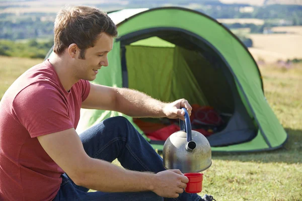 Homem jovem acampar no campo — Fotografia de Stock