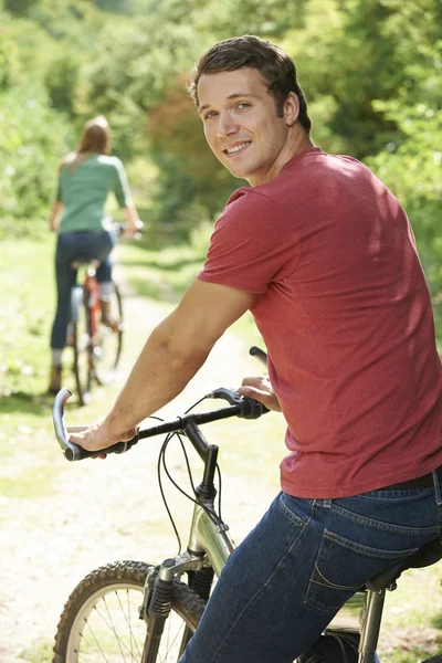 Young Couple Cycling Along Country Track Stock Image