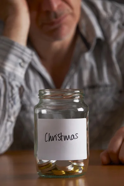 Deprimido hombre mirando vacío tarro etiquetado Navidad — Foto de Stock