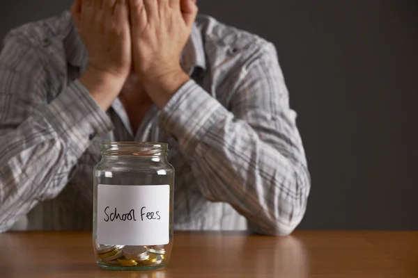Man With Head In Hands Looking At Jar Labelled School Fees — Stock Photo, Image