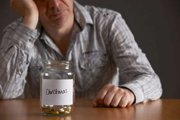 Depressed Man Looking At Empty Jar Labelled Christmas — Stock Photo, Image