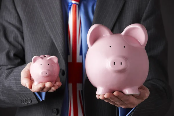 British Businessman Holding Large and Small Piggy Bank — Foto de Stock