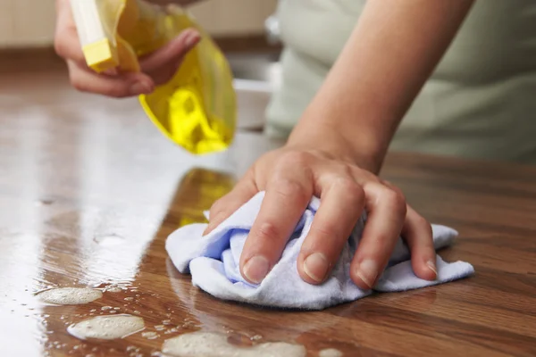 Mujer usando spray limpiador en superficie de madera — Foto de Stock