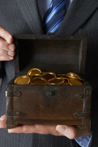 Affärsman Holding trä bröstet med guldmynt inuti — Stockfoto