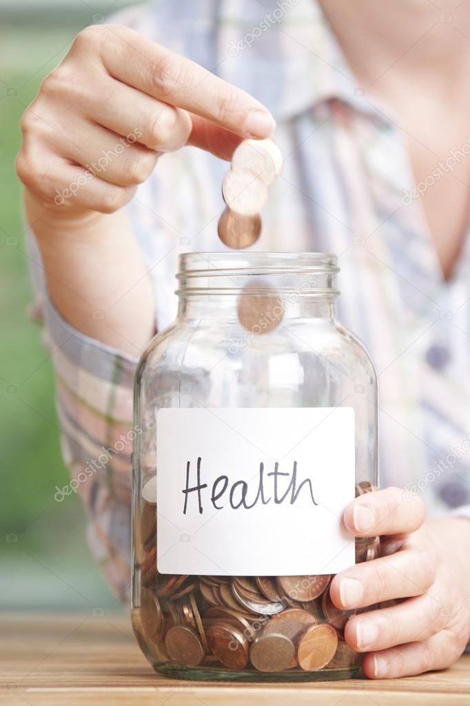 Woman Dropping Coins Into Glass Jar Labelled Health