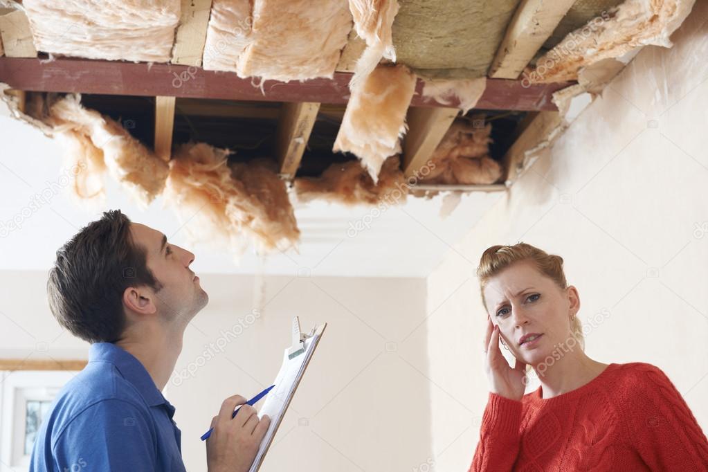Builder And Customer Discussing Ceiling Repair