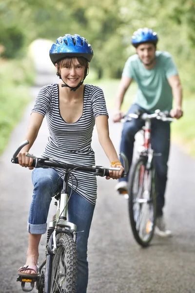 Jeune couple à vélo le long de la route de campagne — Photo