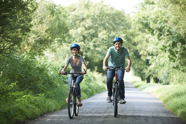 Young Couple Cycling Along Country Lane — Stock Photo, Image