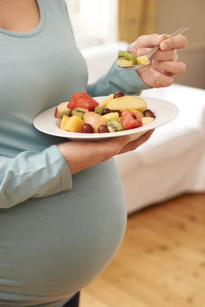 Kobieta w ciąży trzyma puchar świeżych owoców z bliska — Zdjęcie stockowe