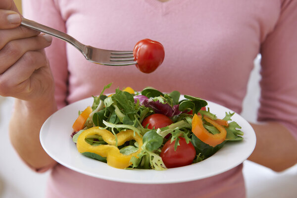 Close Up Of Woman Holding Bowl Of Fresh Salad