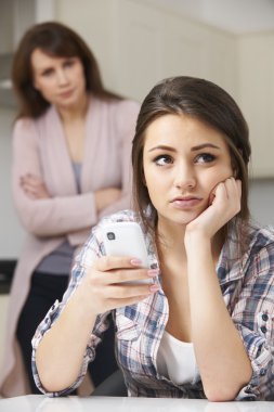 Mother Arguing With Daughter Over Use Of Mobile Phone clipart