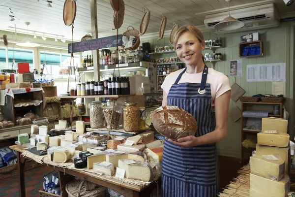 Ιδιοκτήτης από το Delicatessen στέκεται στο κατάστημα κρατώντας καρβέλι — Φωτογραφία Αρχείου