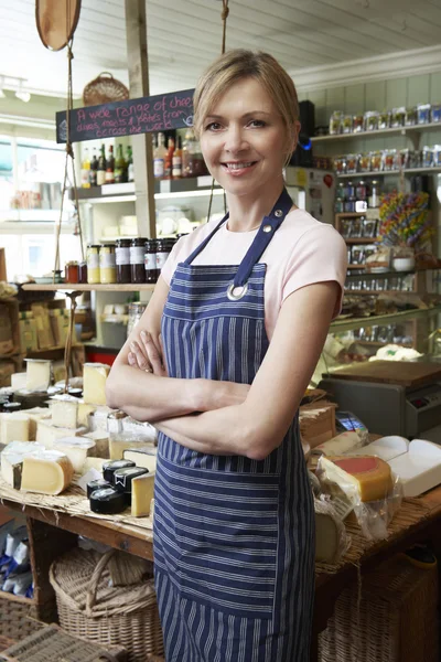 Eigenaar van delicatessen staande in winkel — Stockfoto