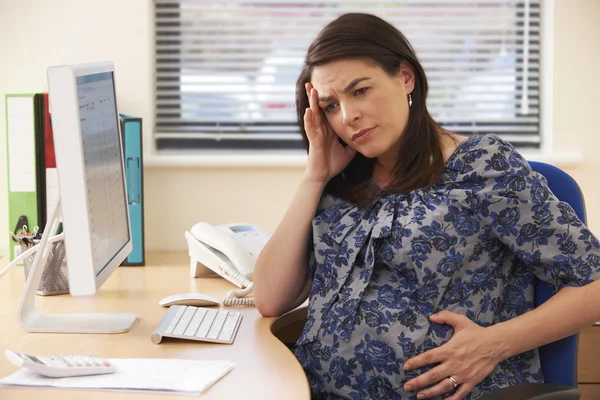 Schwangere Geschäftsfrau wirkt gestresst im Amt — Stockfoto