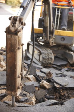 İnşaat işçisi matkap ile yol yüzeyi onarma