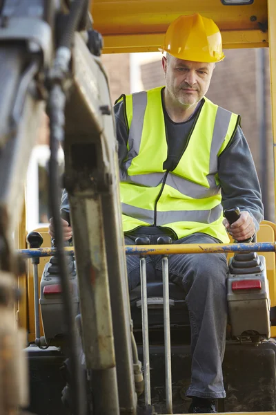 Bauarbeiter bedient Bagger auf Baustelle — Stockfoto