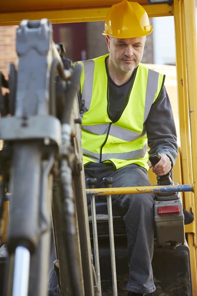 Bauarbeiter bedient Bagger auf Baustelle — Stockfoto