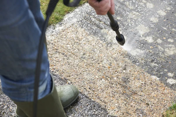 Mann wäscht Betonweg mit Hochdruckreiniger — Stockfoto