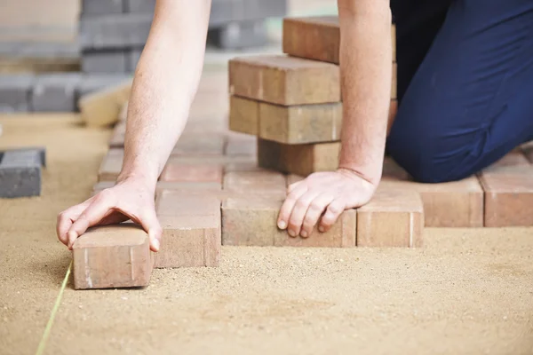 Hombre colocando bloques para el patio — Foto de Stock