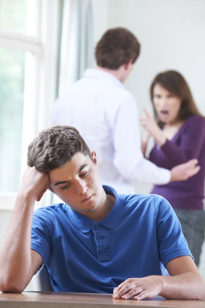 Adolescent malheureux garçon avec parents argumentant en arrière-plan — Photo