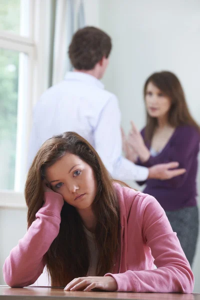 Adolescente malheureuse avec des parents se disputant en arrière-plan — Photo